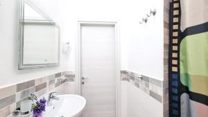 a white bathroom with a sink and a mirror at Casa Iris in Capoliveri +29 photos