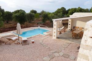 - une piscine avec une terrasse et une maison dans l'établissement Trullo FICOLI, à Ostuni