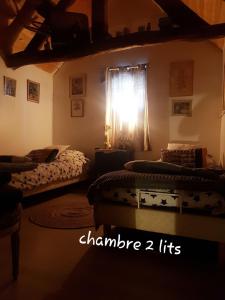 a bedroom with two beds and a window with the light shining through at Mimi la Sardine in Saint-Gervais en-Belin