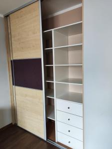 a closet with white shelves and white drawers at Apartament Arena in Zgorzelec