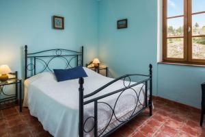 Schlafzimmer mit einem Bett mit blauer Wand in der Unterkunft Le Relais de Tamaroque in Portel-des-Corbières