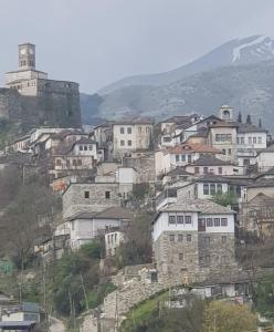 een stel huizen op een heuvel met een toren bij The Stone Sky Hotel in Gjirokastër