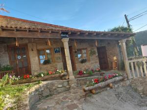 a stone house with flowers in front of it at Casa Luz in Lires