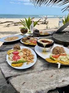 a table with plates of food on the beach at Bob Marley Beach in Guachaca
