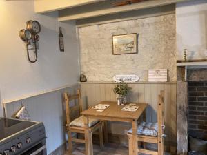 een kleine keuken met een houten tafel en stoelen bij Willow Cottage in Middleton in Teesdale