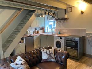- un salon avec un canapé en face d'une cuisine dans l'établissement Willow Cottage, à Middleton in Teesdale
