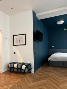a bedroom with a bed and a blue wall at MIRO Rooms - quiet chic, free parking, self check-in in Rīga
