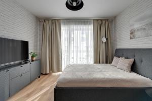 格但斯克的住宿－Grand Apartments - Studio Wałowa 2 apartment in the center of Gdańsk，一间卧室配有一张床和一台平面电视