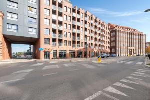 格但斯克的住宿－Grand Apartments - Studio Wałowa 2 apartment in the center of Gdańsk，一条空的街道,在一座大型砖砌建筑前