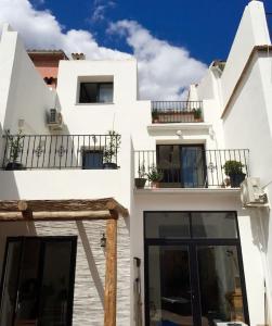 un edificio blanco con ventanas y balcones. en Costa Blanca belle maison entre mer et montagne, en Adsubia