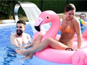 a man and a woman in a pool on a pink flamingo at Apartmani Breza in Vrdnik