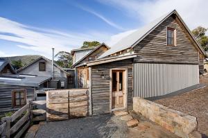 a small wooden house with a garage at The Barn by Tinkersfield in Crackenback