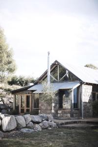 a stone house with a rock wall in front of it at The Barn by Tinkersfield in Crackenback +22 photos