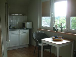 a kitchen with a table and chairs and a microwave at Ferienwohnung am Reiherbach in Bielefeld
