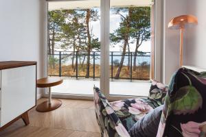 a living room with a couch and a large window at VacationClub - Let’s Sea Baltic Park B40 in Gąski