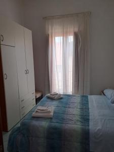 a bedroom with a bed and a dresser and a window at La Casa Di Checco in Santa Maria di Castellabate