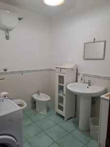 a bathroom with two sinks and a toilet at La Casa Di Checco in Santa Maria di Castellabate