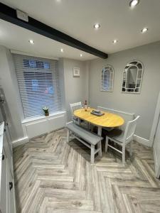a dining room with a wooden table and chairs at Quirky cottage in the centre of Penrith with a Hot Tub in Penrith