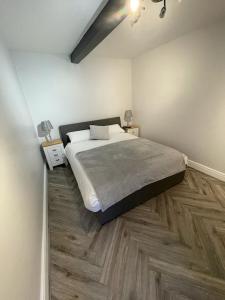 um quarto com uma cama grande e pisos em madeira em Quirky cottage in the centre of Penrith with a Hot Tub em Penrith