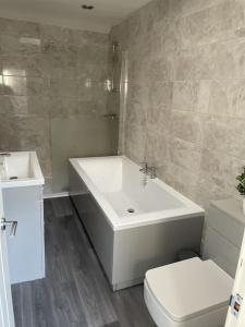 uma casa de banho com um lavatório branco e um WC. em Quirky cottage in the centre of Penrith with a Hot Tub em Penrith