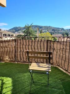 a bench sitting on the grass next to a brick wall at Charmant T2 55m2 4P [Circuit du Castellet /Plages] in Le Beausset