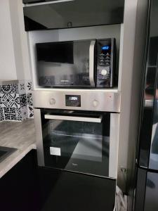 a microwave sitting on top of an oven at Charmant T2 55m2 4P [Circuit du Castellet /Plages] in Le Beausset