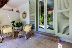 a porch with two wicker chairs and a window at Cape Standard Guest House in Cape Town