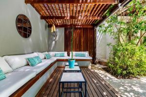 un patio con un sofá blanco y una mesa en Cape Standard Guest House, en Ciudad del Cabo