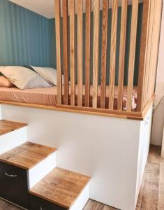 - une chambre avec un lit bébé et 2 sièges en bois dans l'établissement Studio56 - Logement Design et Cosy à Etang Salé, à L'Étang-Salé