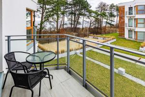 a balcony with a table and chairs and a view of a yard at VacationClub - Let’s Sea Baltic Park B42 in Gąski