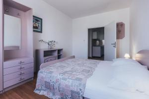 - une chambre blanche avec un lit et une commode dans l'établissement Villa Porta, à Biograd na Moru