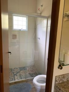 La salle de bains est pourvue d'une douche et de toilettes. dans l'établissement Fazenda Camping Cabral, à São Lourenço