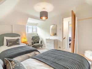 a bedroom with a bed and a chair at Longridge in Peldon