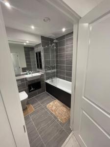 a bathroom with a tub and a toilet and a sink at BrandNew Luxurious 2Bed Apartmnt in Bexleyheath
