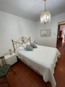 - une chambre avec un lit blanc et un lustre dans l'établissement Casa Evaluna, à San Pedro