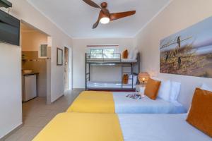 1 dormitorio con 1 cama y ventilador de techo en Lotan Desert Travel Hotel, en Naẖal Ya‘alon