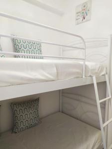 a white bunk bed with a pillow on top of it at Sunset by the sea 2 in Loutraki
