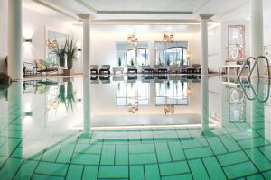 uma piscina com azulejos verdes no chão em Hotel Bayerischer Hof em Oberstaufen