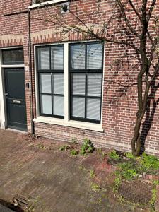 un edificio de ladrillo con una ventana y una puerta en ‘T Singeltje, en Leiden