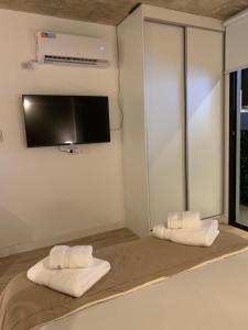 Habitación con 2 toallas y TV en la pared. en Departamento BALCARCE en Salta