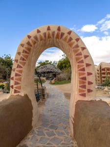 a brick archway with a stone walk way at Lotan Desert Travel Hotel in Naẖal Ya‘alon