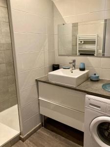 biała łazienka z umywalką i lustrem w obiekcie Ma MaiSon w mieście Marseillan +9 zdjęć