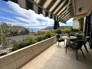 a patio with a table and chairs and a view at Monteview Duplex in Herceg-Novi