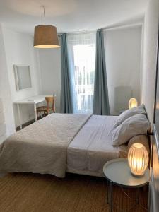 sypialnia z łóżkiem i stołem z dwiema lampami w obiekcie Ma MaiSon w mieście Marseillan