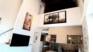 una sala de estar con 2 cuadros en la pared en Πέτρα, Ελιά και Λεβάντα, en Tolo