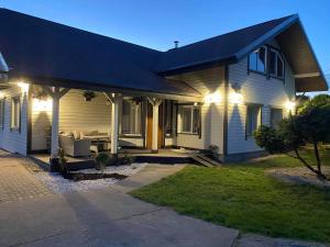 une maison blanche avec terrasse couverte la nuit dans l'établissement Sakalų sodyba, 