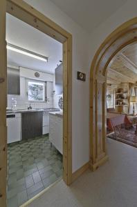 une cuisine avec une arche menant à une salle à manger dans l'établissement Apartment in the heart of Celerina with garden, à Celerina