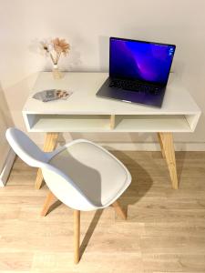 escritorio blanco con ordenador portátil y silla en Departamento BALCARCE en Salta
