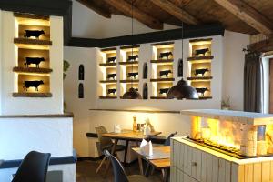 un restaurant avec une cheminée, une table et des chaises dans l'établissement Hotel Bayerischer Hof, à Oberstaufen