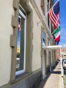 twee Amerikaanse vlaggen op een gebouw met een raam bij Hotel Smart Cruise in Civitavecchia